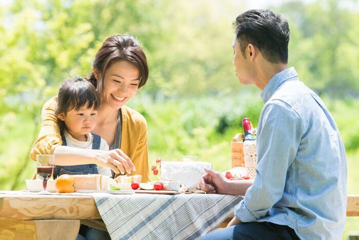 外で家族で食事をする画像